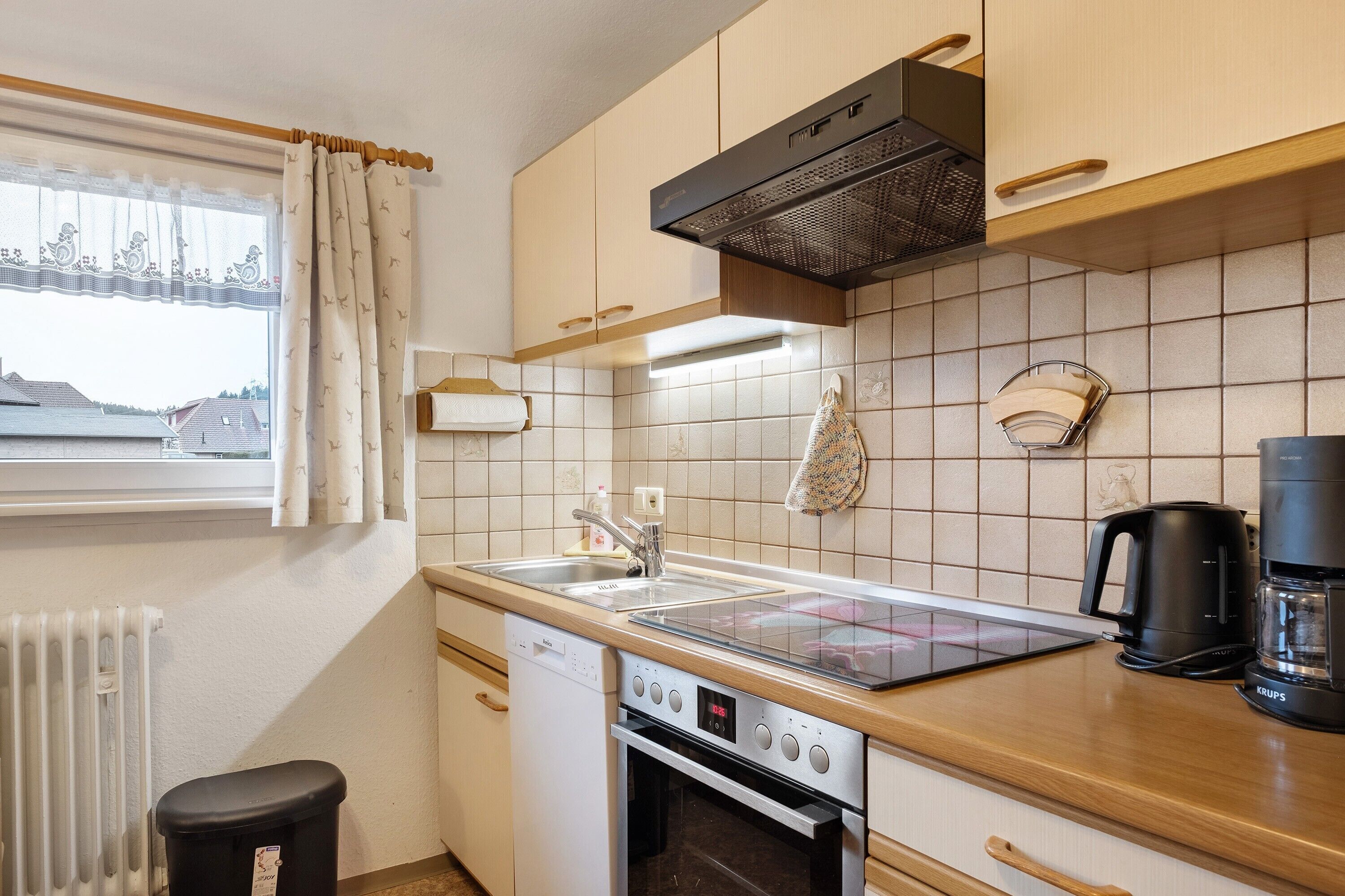 A compact kitchen with a dishwasher, oven, and a coffee maker.