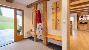 A wooden bench with a coat rack, a door leading outside, and a wall with mounted animal skulls. - Holiday Home Wendelhof Apartment Fuchsbau (Eisenbach (Hochschwarzwald))