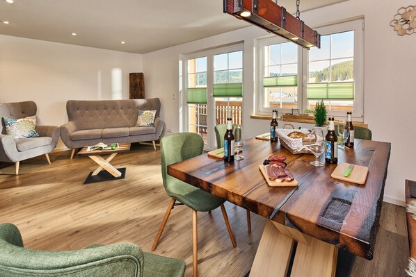 Una sala de estar moderna con un sofá, una mesa de comedor y sillas.