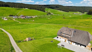 A rural landscape with a large house, a playground, and a road.