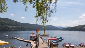 Une jetée au bord du lac, avec des bateaux amarrés, un quai et un panneau indiquant un lieu.