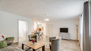 A modern living room with a sofa, armchairs, a coffee table, and a television. - Bergliebe Apartment with Private Terrace and Wi-Fi (Sasbach)