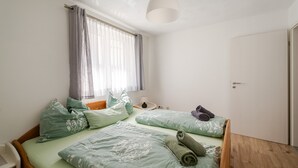 A room with a bed, a bedside table, a lamp, and a window with curtains. - Bergliebe Apartment with Private Terrace and Wi-Fi (Sasbach)