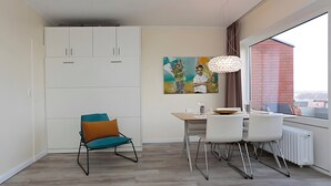 Un espace repas moderne comprenant une table, des chaises et un tableau accroché au mur.