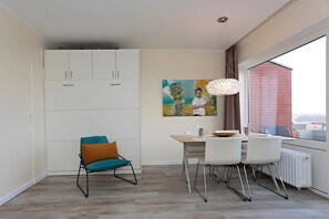 Un comedor moderno con una mesa, sillas y un cuadro en la pared.