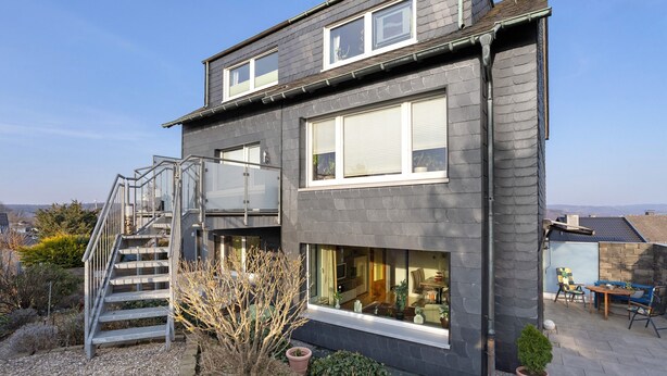 A modern two-story house with a staircase, large windows, and a patio area. - Holiday Apartment 'Auszeit' with Private Terrace, Shared Garden and Wi-Fi (Arnsberg)