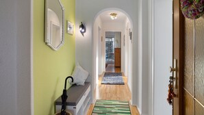 A hallway with a bench, a mirror, and a door with a decorative wreath. - Holiday Apartment 'Auszeit' with Private Terrace, Shared Garden and Wi-Fi (Arnsberg)