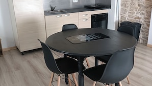 Una cocina moderna con alacenas de madera clara, un refrigerador de acero inoxidable y un horno empotrado.