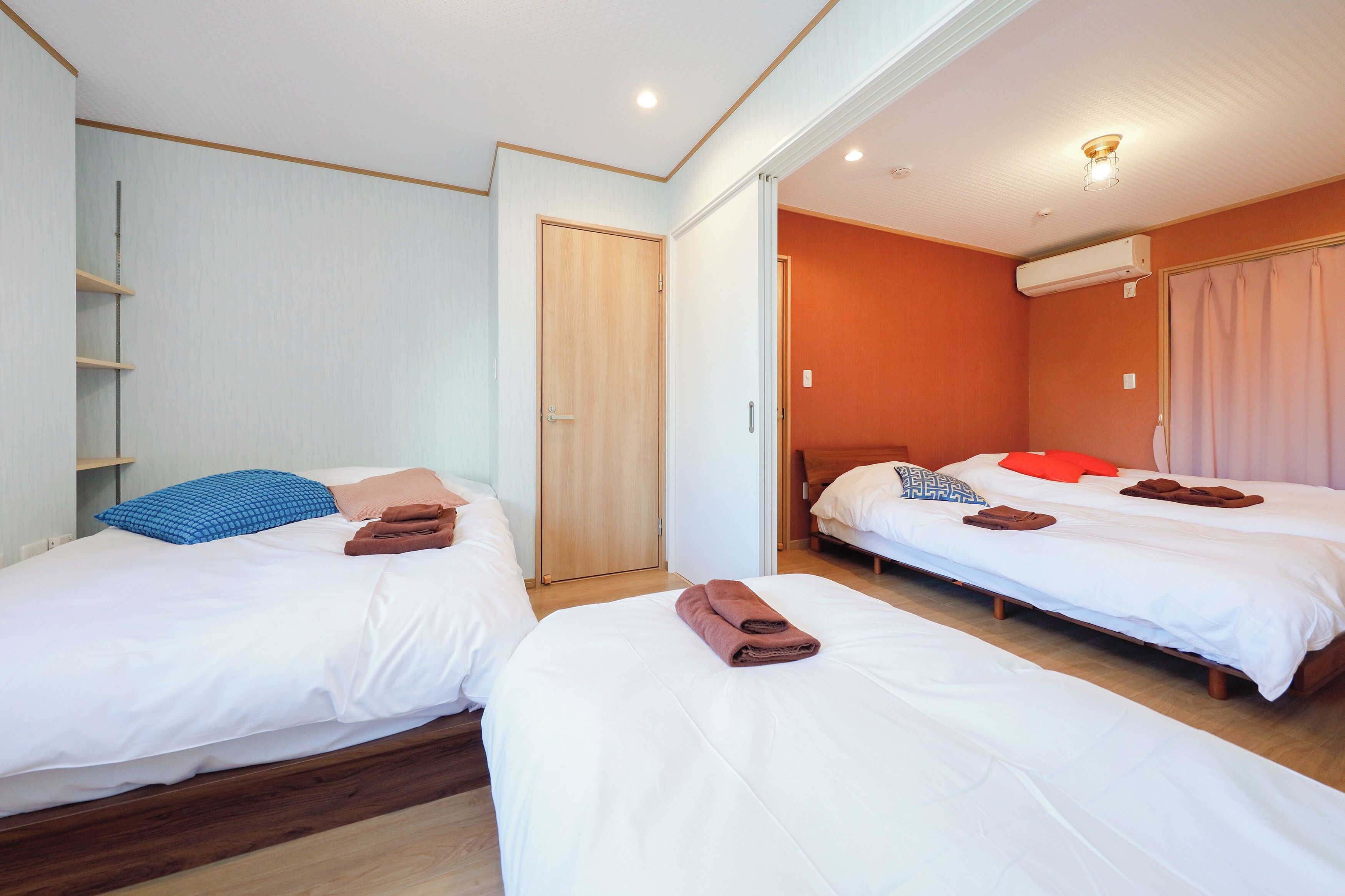 Une chambre d’hôtel avec deux lits, une armoire et un appareil de climatisation.
