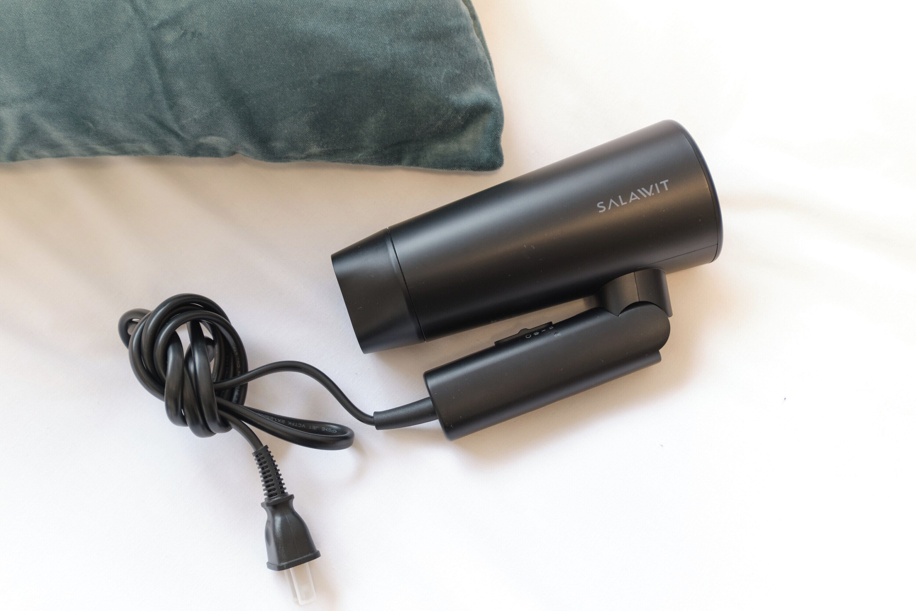 A black portable charger with a cable and adapter on a white surface.