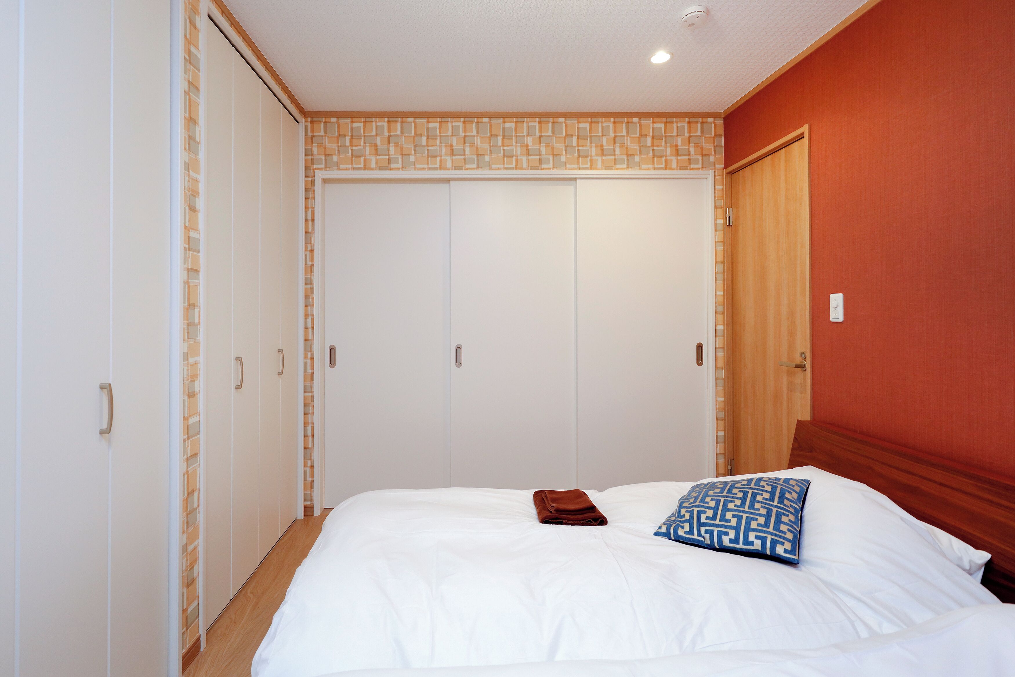 Un dormitorio con una cama grande, un armario y una puerta.