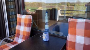 A balcony with two plaid chairs, a small table, and a decorative item. - "Sunny spot" dreamy sunsets included! (Dahme)