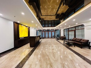 A spacious lobby with a reception desk, seating area, and a staircase leading to an upper level. - Hanoi Apartment  (Hanoi)