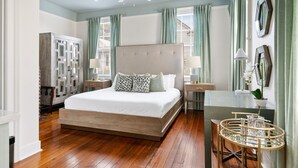 A bedroom with a large bed, a ceiling fan, a desk, and a chair. - Stylish 3BR | Sleeps 6 | Walk Everywhere (Charleston)