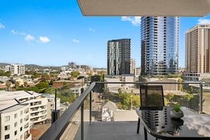 Enjoy the city view from the spacious balcony with a comfortable seating area.