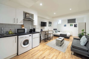 A modern apartment with a kitchen, a dining area, and a living room.