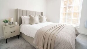 A bedroom with a bed, bedside table, and a window. - Stunning 1BR Cheltenham Suite Near Town Centre (Cheltenham)