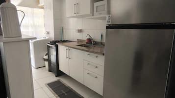 Een magnetron, een oven, een kookplaat, kookgerei, borden en bestek