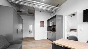 A modern, compact living space with a kitchenette, a dining area, and a separate sleeping area. - Homaris Apartments Isartor (Munich)