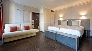 A modern bedroom with a bed, a sofa, and a bench. - Hôtel Jean Moët (Épernay)