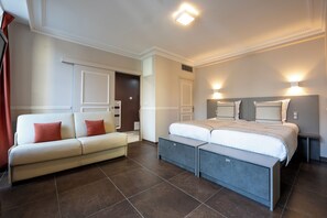 A modern bedroom with a bed, a sofa, and a bench. - Hôtel Jean Moët (Épernay)