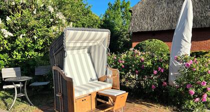 Reed-roofed FH with beach chair in the garden and close to the beach