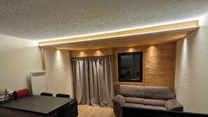 A compact living space with a kitchenette, a sofa, and a dining area.