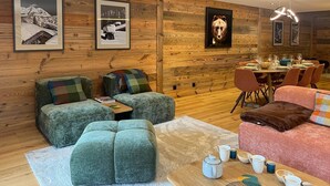 A cozy living room with wooden walls, a dining area, and a fireplace. - Spacious apartment in Les Gets, 4 bedrooms, sauna (Les Gets)