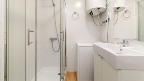 Une salle de bain moderne avec une douche à parois de verre, un lavabo blanc et des toilettes.