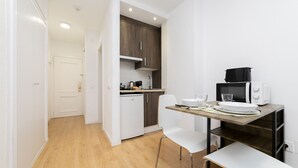 Une cuisine compacte équipée d’un four à micro-ondes, d’un évier et d’un petit coin repas avec une table et des chaises.