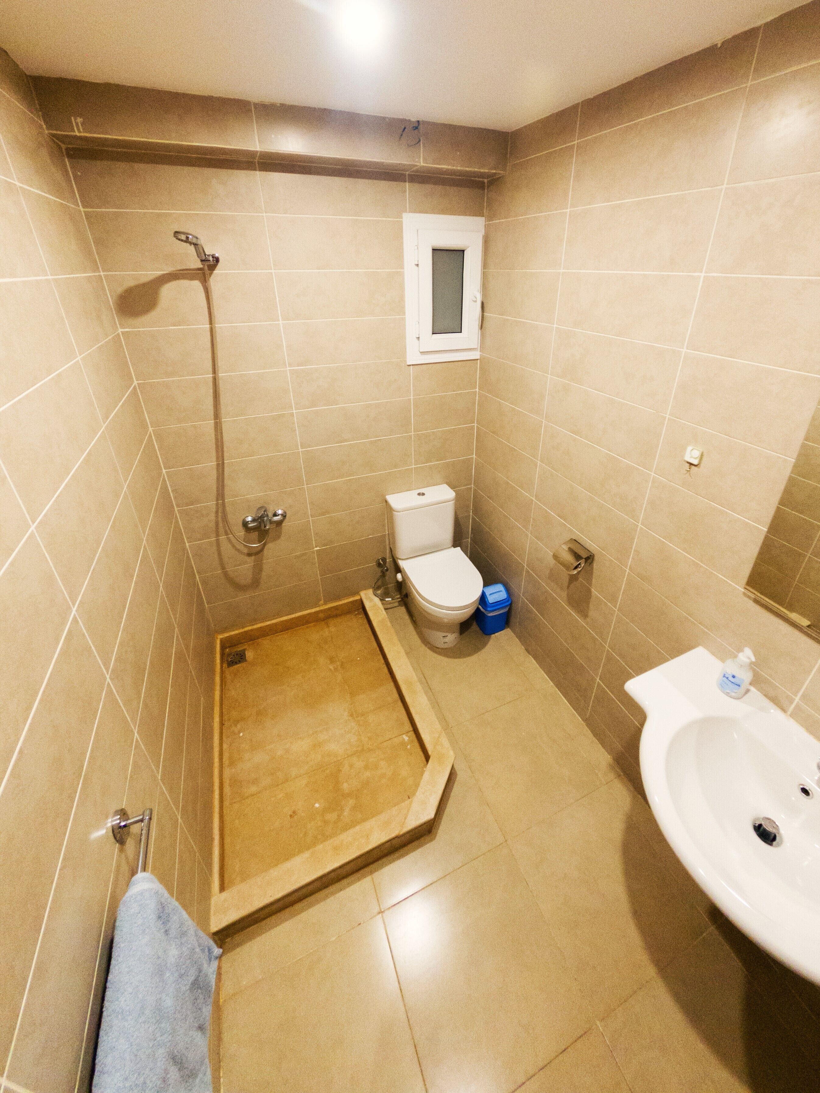 A bathroom with a shower, toilet, and sink.