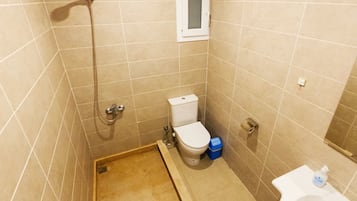 A bathroom with a shower, toilet, and sink.