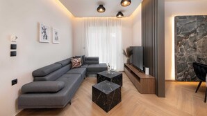 Una sala de estar moderna con un sofá seccional, un televisor de pantalla plana y una mesa de centro de mármol.