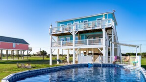 A two-story house with a swimming pool in front.