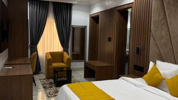 Ein modernes Hotelzimmer mit einem großen Bett, einem Schreibtisch, einem Stuhl und einer Couch.
