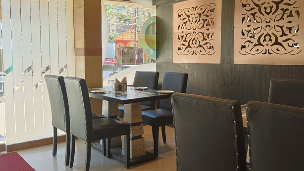 Comedor con una mesa dispuesta para cuatro personas, rodeada de sillas.