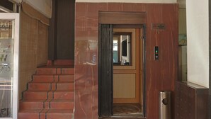 Una escalera que conduce a un ascensor con un letrero que dice "No Smoking".