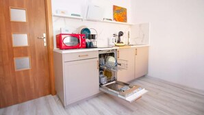Una cucina compatta con forno a microonde, lavastoviglie e un piccolo piano di lavoro.