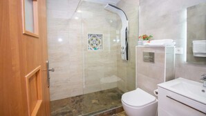 A modern bathroom with a glass-enclosed shower, a toilet, and a vanity with a mirror. - Art Apartment IV, Two-Bedroom Apartment (Alicante (Alacant))