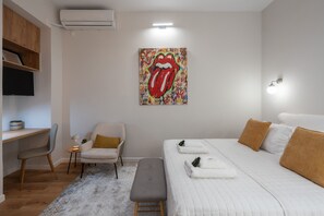 A modern bedroom with a large bed, a desk, a chair, and a wall-mounted artwork. - Loft Suite In Syntagma |Metro |Best Location (Athens)