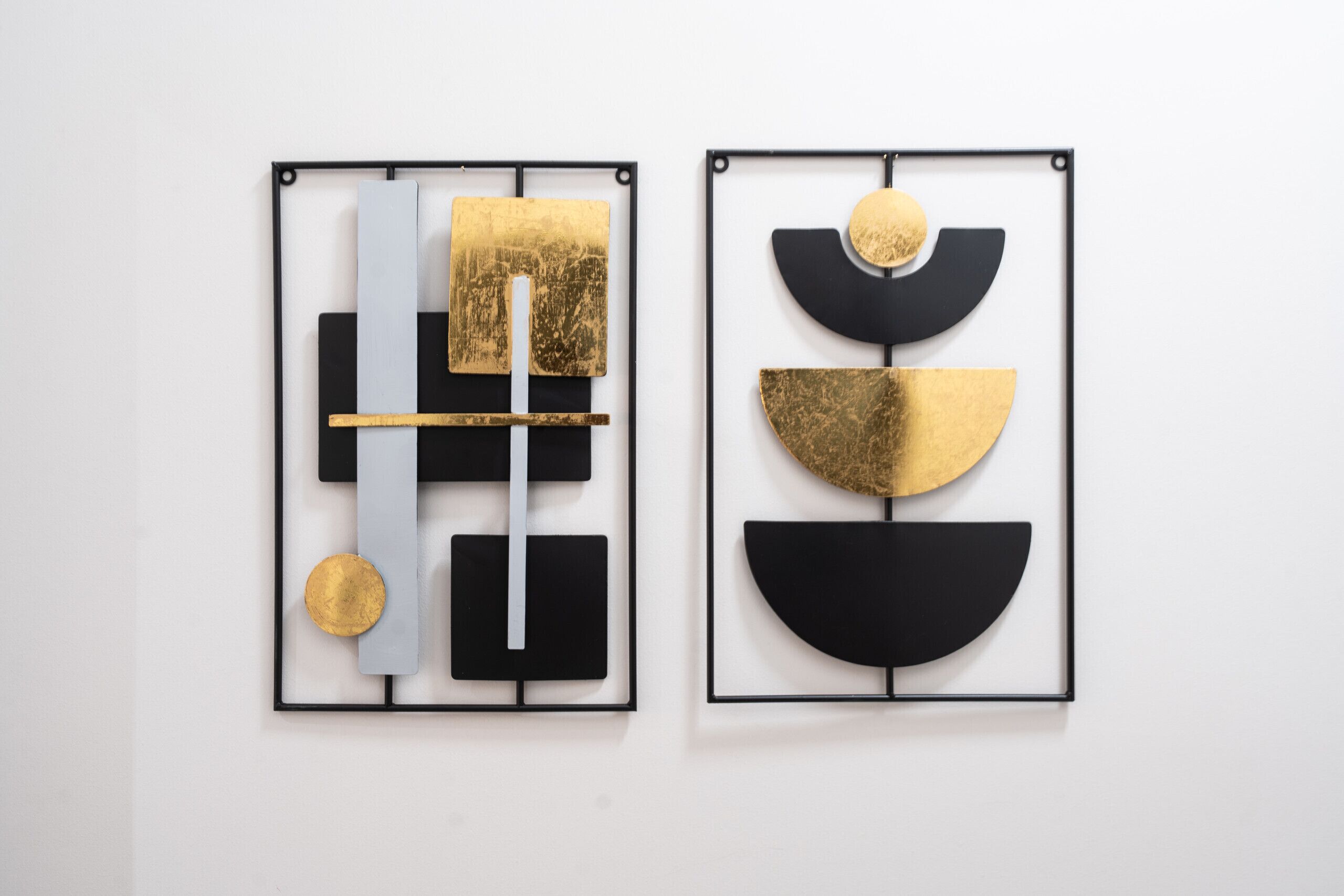 Two framed abstract artworks with geometric shapes and gold accents.