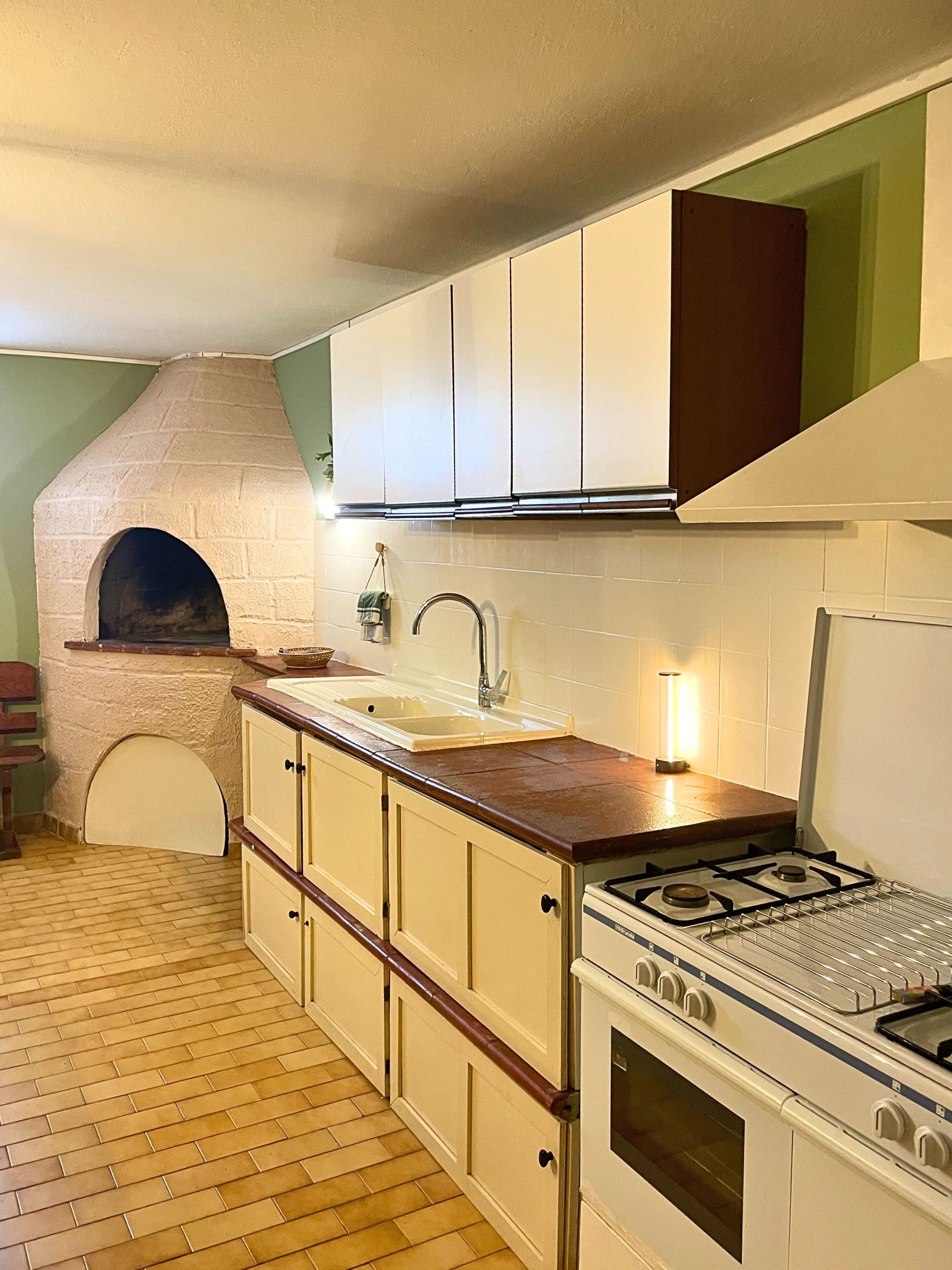 Une cuisine équipée d’un four encastré, d’un évier et d’une cuisinière.