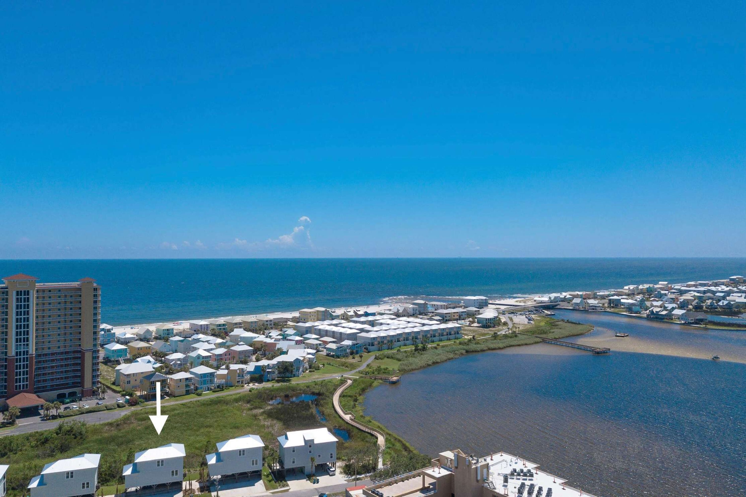 A coastal resort with multiple-story buildings, a marina, and a beach.