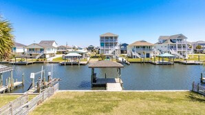A waterfront property with multiple buildings, docks, and a small gazebo. - Sunsets on Broadway - Stunning 4 BR Home - Dock & Great Outdoor Spaces (Surf City)