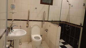 A small bathroom with a toilet, sink, and shower. - luluat althuraya serviced apartmints 8 (Riyadh)