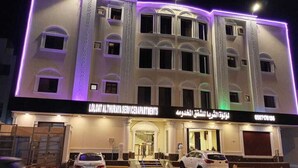 A multi-story building with a service entrance and two cars parked in front. - luluat althuraya serviced apartmints 8 (Riyadh)