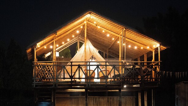 A large, well-lit tent with a wooden frame and a covered walkway. - Tuk Tuk Gilhari Noida (Noida)