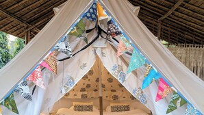 A tent with two beds, a central table with a kettle, and a woven mat. - Tuk Tuk Gilhari Noida (Noida)