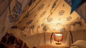 A tent with a bed, a table, and a lamp. - Tuk Tuk Gilhari Noida (Noida)