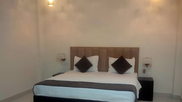 Een moderne slaapkamer met een groot bed, twee nachtkastjes en twee hanglampen.